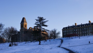 The sun rises above McGraw Hall and Libe Slope.