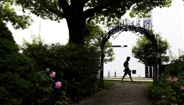 A student walks by the Minns Garden gate.