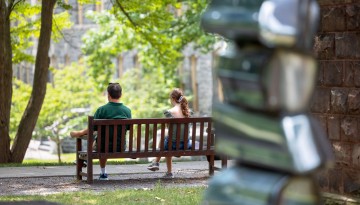 Cornell visitors have a quiet moment on the benches outside Tjaden Hall.