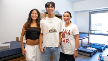 A family pauses unpacking to pose for a picture. 