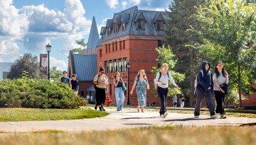 Students walk along Feeney Way near Sage Hall.
