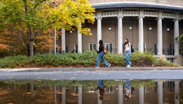 Bailey Hall is reflected in a rain puddle.