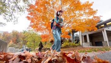 Students walk the Triphammer footbridge by Beebe Lake