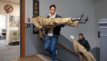 ROTC cadets carry mannequins up the steps of Barton Hall in preparation for the “Fit for Duty” exhibition.