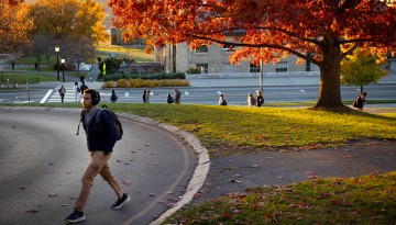 A student walks along Feeney Way.