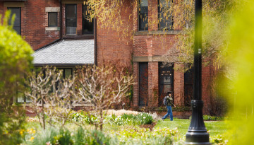 Person walks past the brick walls of the A.D. White House