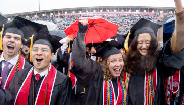 Graduates cheering on the field. 