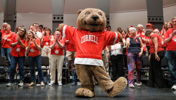 Bear mascot in front of reunion attendees