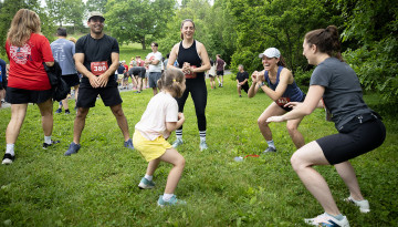 Reunion attendees wearing running numbers do squats