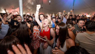 Reunion attendees dance under a tent