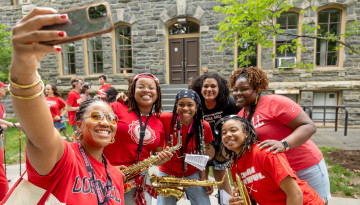 A group of reunion attendees with musical instruments pose for a selfie