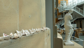 Origami boats are collected on a ledge in the Temple of Zeus.