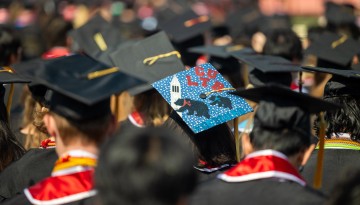 A custom cap stands out in the crowd of graduates.