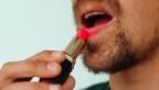 Man applying lipstick